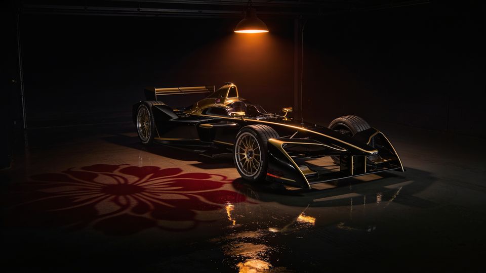 A black and gold race car in a dark garage